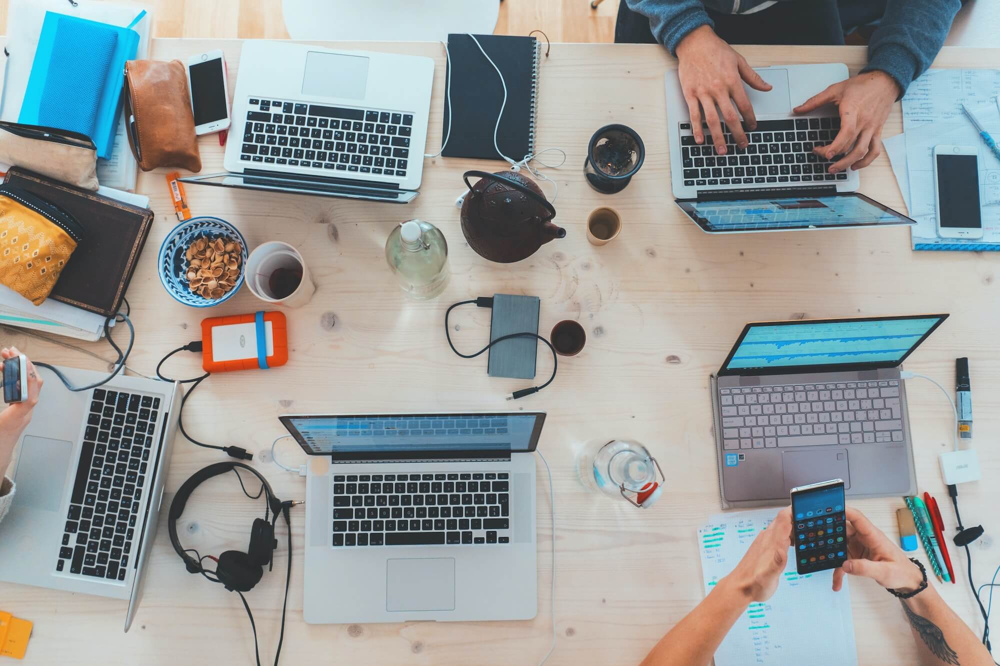 Overhead shot table with multiple workers and laptops.