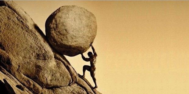 Man holding back a huge boulder on a steep side of a mountain.